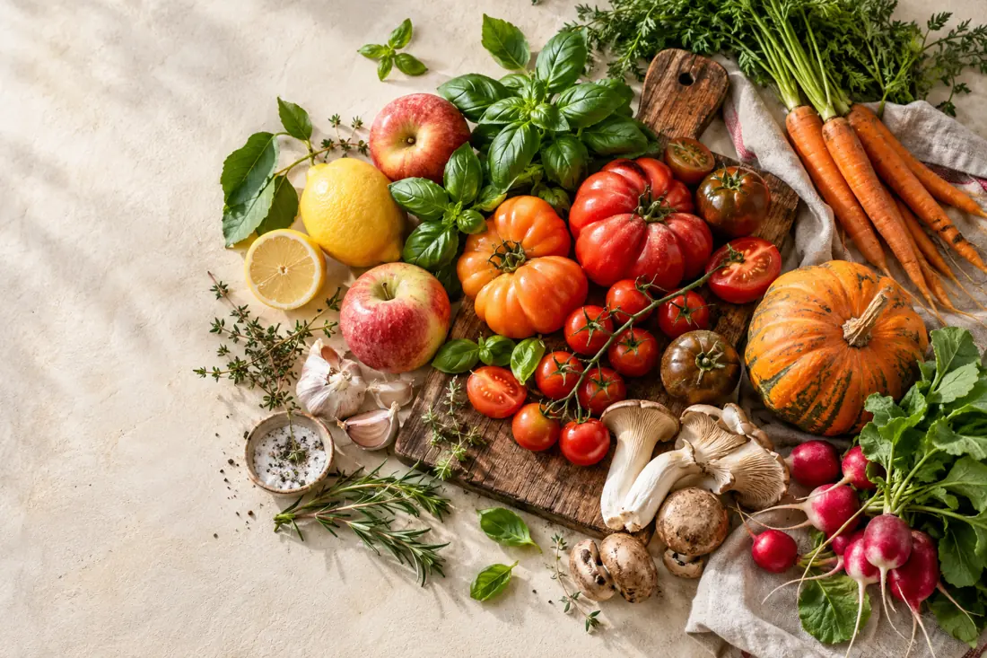Frisches Gemüse, Obst und Kräuter auf einem Küchentisch